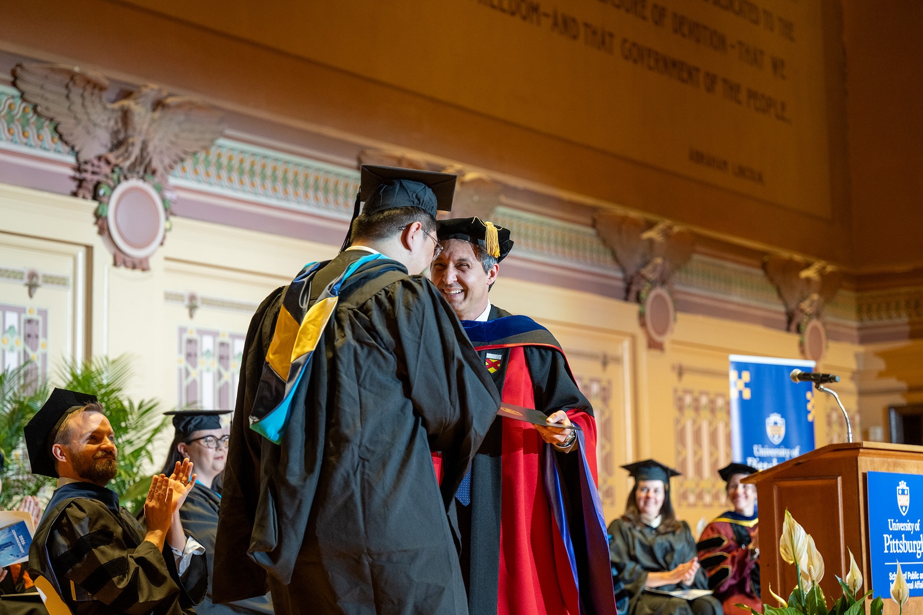 Dr. Condra greets a graduating students on stage at Commencement