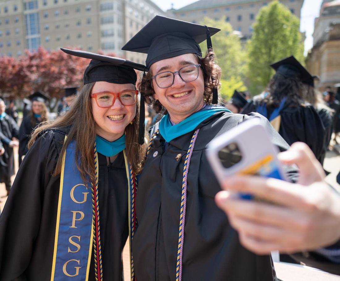 Two students take a selfie at graduation